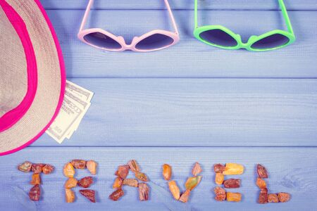 Vintage photo, Summer time. Inscription travel made of amber, currencies dollar, sunglasses and straw hat, copy space for textの写真素材