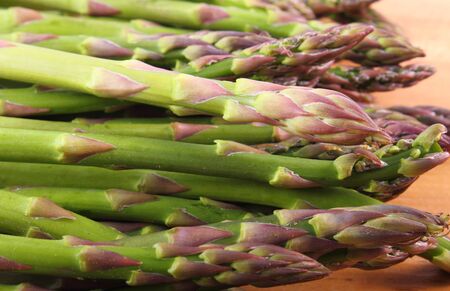 Fresh green asparagus on wooden surface, concept of healthy food, nutrition and strengthening immunityの写真素材