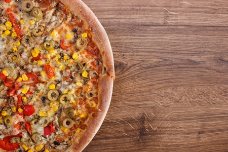 Fresh baked vegetarian pizza with vegetable on rustic wooden background, italian cuisine, fast food, copy space for text or inscriptionの写真素材