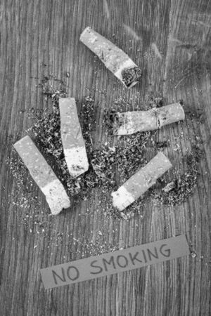 Cigarette butts and ash with inscription no smoking, concept of healthy lifestyles without cigarettes, world no tobacco dayの写真素材