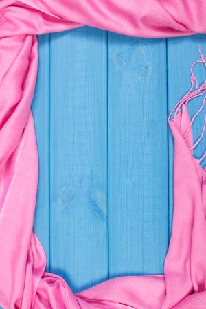 Frame of pink shawl for woman on boards, womanly accessories, warm clothing for autumn or winter, copy space for textの写真素材