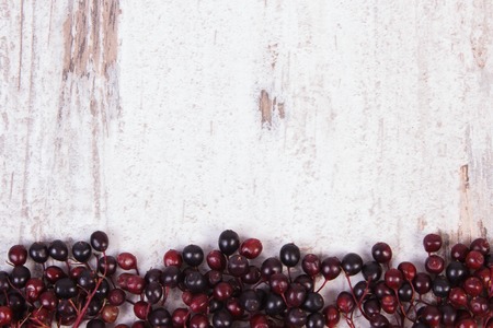 Autumn fresh elderberry and copy space for text on old rustic wooden background, healthy nutrition, alternative medicine and therapyの写真素材