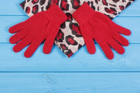 Pair of woolen gloves and colorful shawl for woman on boards, womanly accessories, warm clothing for autumn or winterの写真素材