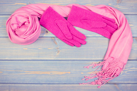Vintage photo, Frame of pink woolen gloves and shawl for woman on old boards, warm clothing for autumn or winter, copy space for textの写真素材
