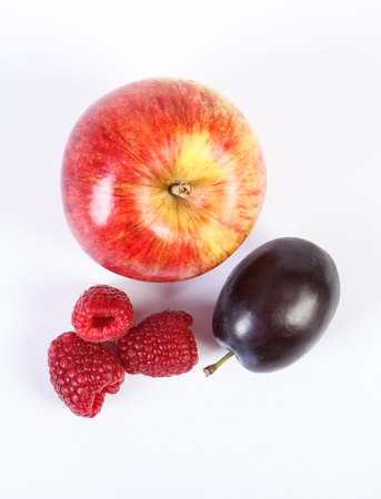 Fresh ripe apple, raspberries and plum on white background, healthy nutritionの写真素材