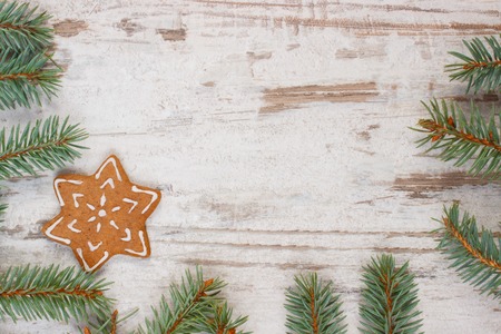 Fresh baked homemade decorated gingerbread, Christmas cookies and green spruce branches on old white...