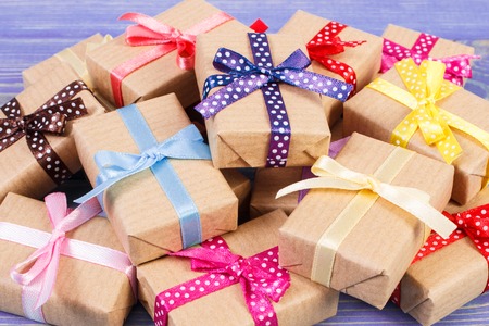 Wrapped gifts with colorful ribbons for Christmas, Valentine, birthday or other celebration lying on old boardsの写真素材