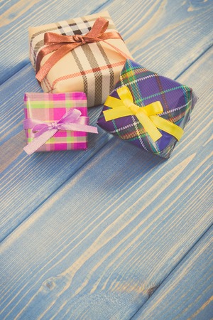 Vintage photo, Wrapped colorful gifts with ribbons for Christmas, Valentine, birthday or other celebration, copy space for text or inscription on old boardsの写真素材