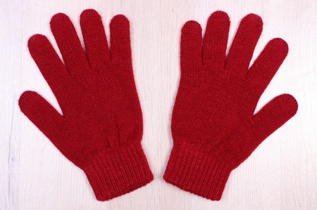 Womanly woolen gloves on wooden board, warm clothing for autumn or winter