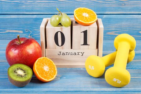 January 1 on cube calendar, fresh fruits and dumbbells for fitness, new years resolutions of healthy lifestyleの写真素材
