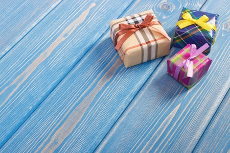 Wrapped colorful gifts with ribbons for Christmas, Valentine, birthday or other celebration, copy space for text or inscription on old boardsの写真素材