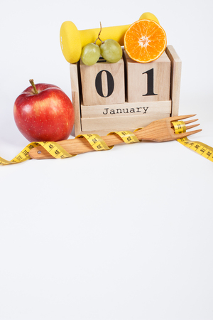 January 1 on cube calendar, fresh fruits, dumbbells and tape measure, new years resolutions of healthy lifestyle, copy space for textの写真素材