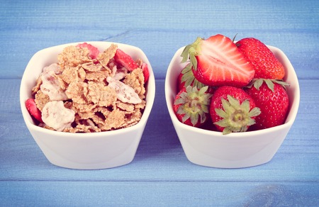 Vintage photo, Fresh strawberries, wheat and rye flakes in glass bowl on boards, concept of healthy lifestyleの写真素材