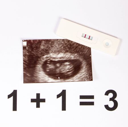 Pregnancy test with positive result and ultrasound scan of baby, concept of extending family and expecting for babyの写真素材