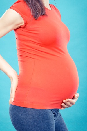 Pregnant woman with stomach pain or back aches, concept of health care, suffering, nausea or indigestion, aches in pregnancy and risk of miscarriageの写真素材