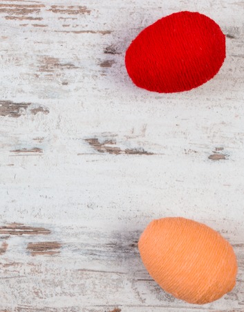 Easter eggs wrapped woolen string on old rustic wooden background, copy space for inscription or textの写真素材