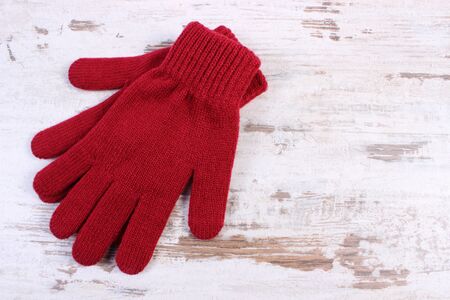 Pair of woolen gloves for woman on old rustic wooden background and copy space for text, womanly accessories, warm clothingの写真素材
