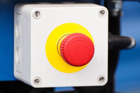 Emergency stop button for hand press on industrial machine, concept of safety at work