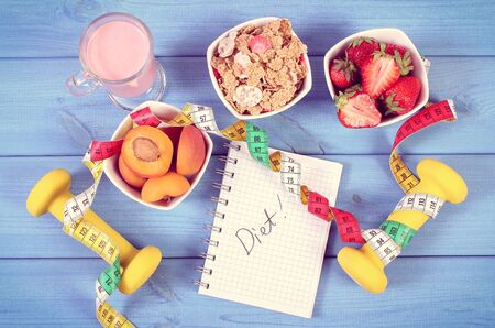 Vintage photo, Fresh healthy food, dumbbells for fitness, tape measure and notebook for writing notes, concept of slimming, healthy, sporty lifestyleの写真素材