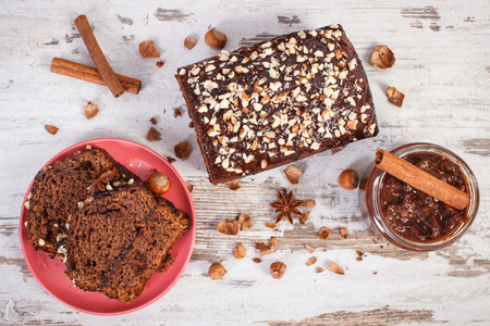 Fresh baked gingerbread or dark cake with cocoa, chocolate and plum jam on old rustic boards, concept of delicious dessertの写真素材