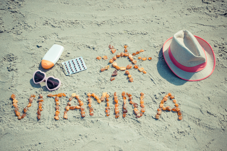 Vintage photo, Medical pills, inscription vitamin A made of amber stones and accessories for sunbathing at beach, concept of healthy, beautiful and lasting tanの写真素材