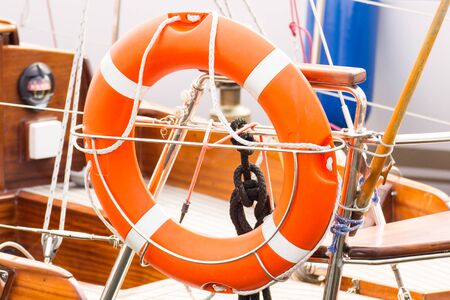 Parts and detail of yachting, Orange lifebuoy on deck of sailboat, concept of safety travelの写真素材