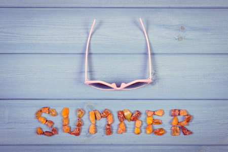 Vintage photo, Inscription summer made of amber stones and sunglasses on boards, summer and vacation timeの写真素材