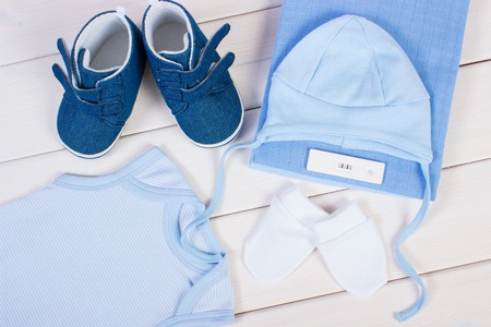 Pregnancy test with positive result and clothing for newborn and kids on boards, concept of extending family and expecting for babyの写真素材