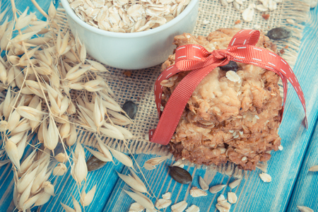 Vintage photo, Fresh baked homemade crusty oatmeal cookies with ingredients and ears of oat, concept of delicious healthy dessertの写真素材
