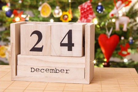 Date 24 December on calendar, festive tree with lights and decoration in background, Christmas eve time conceptの写真素材