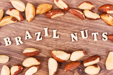 Inscription brazil nuts and fruits as source of natural minerals and vitamin, healthy nutrition conceptの写真素材