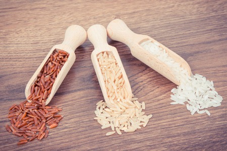 Vintage photo, Red, brown and white rice seeds on wooden scoop, concept of healthy nutritionの写真素材