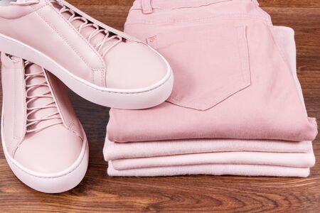 Pink leather shoes, pants and clothing for woman lying on rustic boardの写真素材