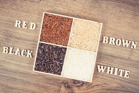 Vintage photo, Heap of white, brown, red and black rice with inscription on rustic board, concept of healthy nutritionの写真素材