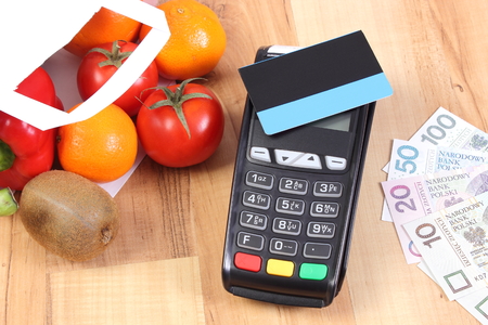 Credit card reader, payment terminal with contactless credit card and polish currency money, choice between cashless and cash paying for shoppingの写真素材