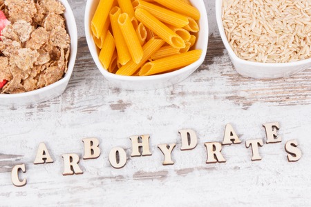 Inscription carbohydrates with natural ingredients and products as source vitamins, minerals and dietary fiber, healthy nutrition conceptの写真素材