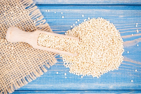 Heap of quinoa seeds with scoop as source vitamins, healthy nutrition conceptの写真素材