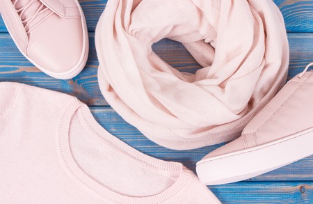 Womanly clothing and accessories on old boards, pink leather shoes, sweater and shawlの写真素材
