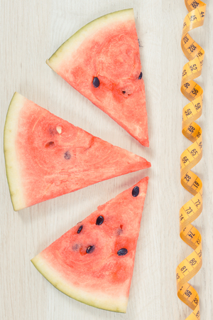 Vintage photo, Fresh juicy watermelon and tape measure, concept of delicious healthy dessert and slimmingの写真素材