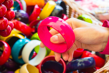 Looking at pink bracelet, shopping jewelry and womanly accessories on stall at bazaar