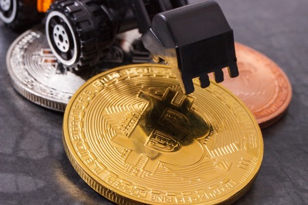 Bitcoin coins with miniature excavator, concept of mining cryptocurrency and modern finance or bankingの写真素材