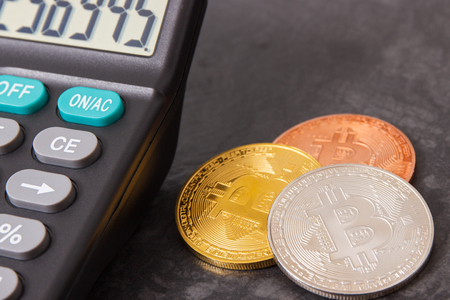 Bitcoin coins with calculator as symbol of cryptocurrency, modern finance and international network paymentの写真素材