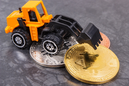 Bitcoin coins with miniature excavator, concept of mining cryptocurrency and modern finance or bankingの写真素材