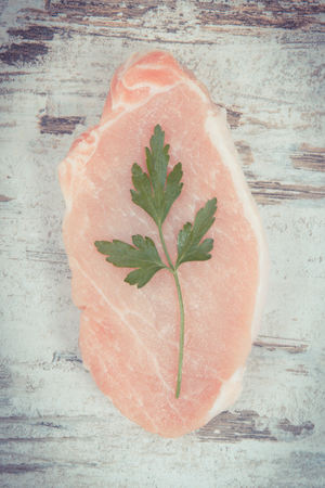Raw meat pork steaks with parsley containing protein for cooking lunch or dinnerの写真素材