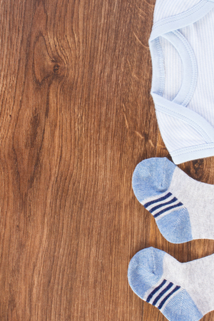 Clothing for baby boy, expecting for newborn concept, copy space for text or inscription on rustic boardの写真素材