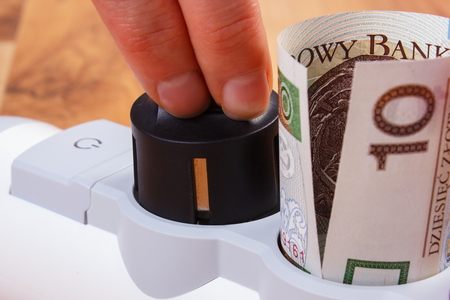 Hand of woman turns off plug from electrical extension, concept of saving money on electricity, energy costsの写真素材