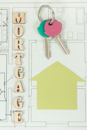 Inscription mortgage, keys and home shape on electrical construction drawing, concept of buying or...