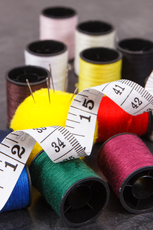 Spools of colorful thread, needle and tape measure. Accessories for sewing and needleworkの写真素材