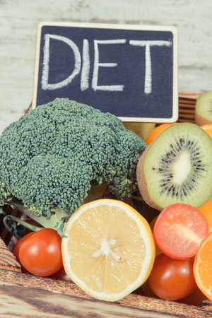 Inscription diet and fresh ripe fruits with vegetables as source natural minerals and vitamins. Diet, slimming and healthy nutrition conceptの写真素材