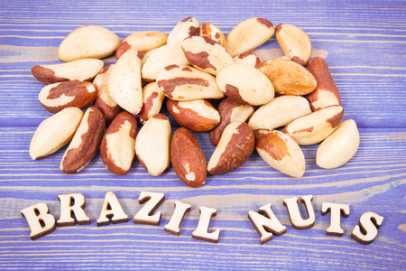 Inscription brazil nuts and heap of fruits as source of natural minerals and vitamin, healthy nutrition conceptの写真素材